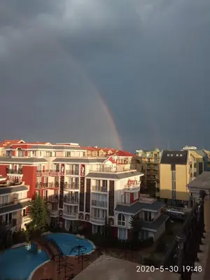 a rainbow in the sky over a city with buildings at Messembria Palace Bulgaria in Sunny Beach