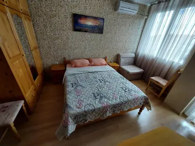 a bedroom with a bed with pink pillows on it at Апартамент Кънтри-Лариса in Pomorie