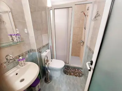 a bathroom with a toilet and a sink and a shower at Апартамент Кънтри-Лариса in Pomorie