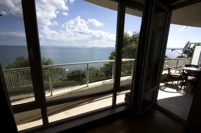 a room with a window looking out at the ocean at Apartmán Alex beach s nádherným panoramatickým výhledem na moře in Sveti Vlas