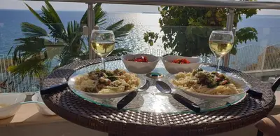 a table with bowls of food and glasses of wine at Apartmán Alex beach s nádherným panoramatickým výhledem na moře in Sveti Vlas