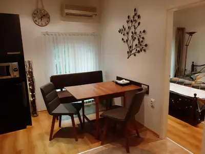 a dining room with a wooden table and chairs at Портхаус in Burgas City