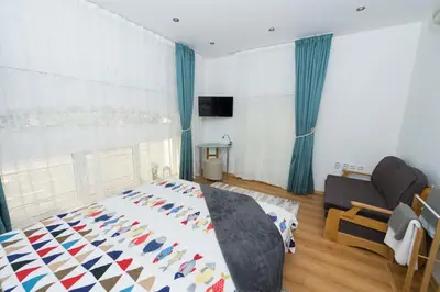 a bedroom with a bed and a couch at Портхаус in Burgas City