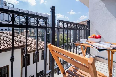 a balcony with a wooden table and a bowl of fruit at Comfy luxury center apartment in Varna City
