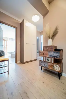 a living room with wooden floors and a large window at Comfy luxury center apartment in Varna City