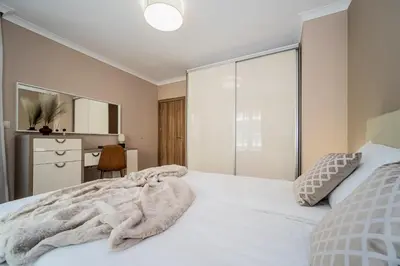 a bedroom with a white bed and a desk at Comfy luxury center apartment in Varna City