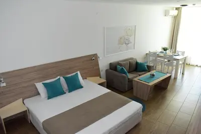 a hotel room with a large bed and a table at Silver beach Studio Byala in Byala