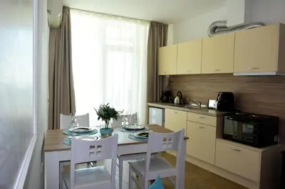 a kitchen with a table with chairs and a microwave at Silver beach Studio Byala in Byala