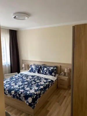 a bedroom with a bed with a blue floral bedspread at Luxury family apartament in Burgas City