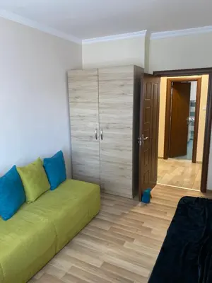 a living room with a green couch and a closet at Luxury family apartament in Burgas City