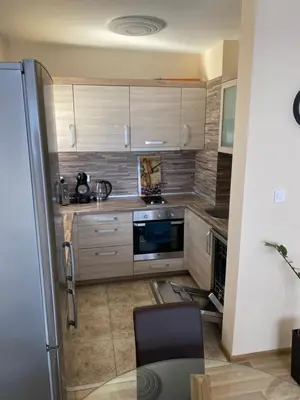 a kitchen with wooden cabinets and a refrigerator at Luxury family apartament in Burgas City