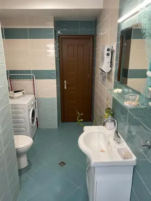 a bathroom with a sink and a toilet and a mirror at Luxury family apartament in Burgas City
