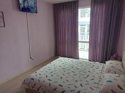 a bedroom with a bed in front of a window at Апартамент Spirit in Nesebar