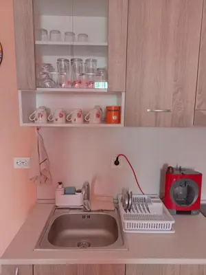 a kitchen with a sink and a red microwave at Апартамент Spirit in Nesebar
