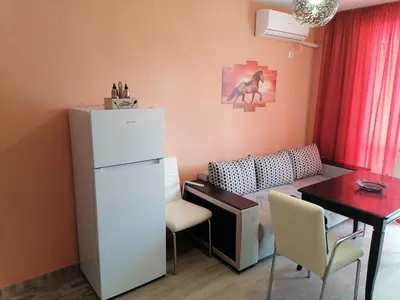 a small kitchen with a white refrigerator and a table at Апартамент Spirit in Nesebar