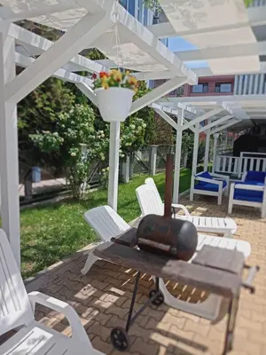 a picnic table and chairs under a white pergola at Апартамент Spirit in Nesebar