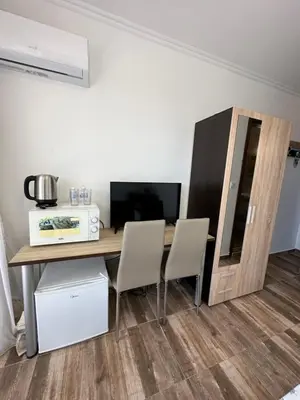 a room with a table and two chairs and a television at Вила Quiet Bay in Sozopol