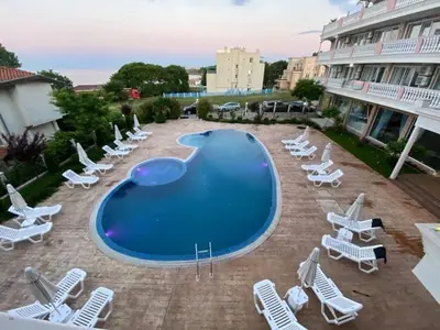 a large swimming pool with lounge chairs and a bunch ofitures at Студио Симона 2 - първа линия море in Lozenets