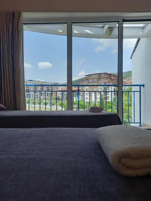 a bedroom with a large window with a view of a building at Vega Village Ap A8 in Sveti Vlas