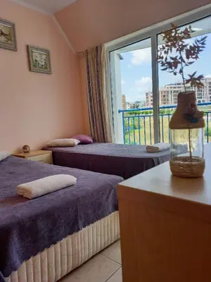 a hotel room with two beds and a window at Vega Village Ap A8 in Sveti Vlas