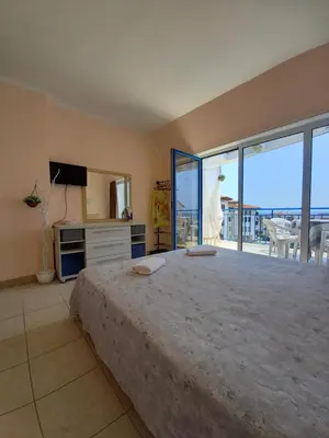 a bedroom with a large bed and a balcony at Vega Village Ap A8 in Sveti Vlas