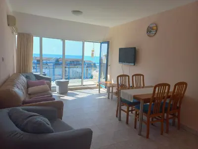 a living room with a couch and a table and chairs at Vega Village Ap A8 in Sveti Vlas