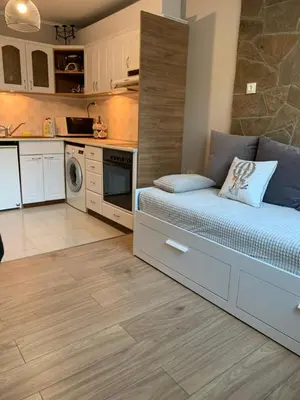 a bedroom with a bed and a kitchen at Анси in Pomorie