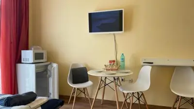 a room with a table and chairs and a tv on the wall at AFRODITA I 108 Studio Sunny Beach in Sunny Beach
