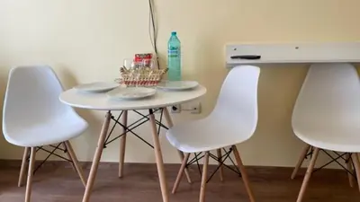 a table with four white chairs and a table with a bottle at AFRODITA I 108 Studio Sunny Beach in Sunny Beach