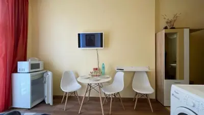a kitchen with a table and four white chairs at AFRODITA I 108 Studio Sunny Beach in Sunny Beach