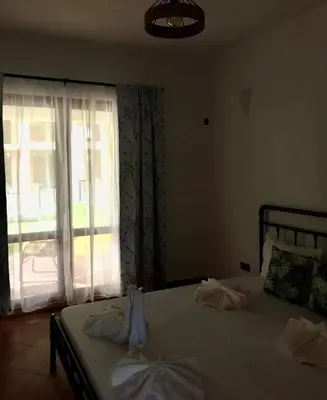 a bedroom with a bed with a large window at Villa Oasis етаж1 in Lozenets