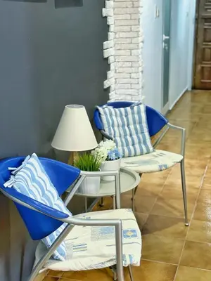 a room with two chairs and a table and a lamp at Апартамент Компас in Burgas City