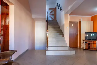 a staircase in a room with a tv and a stair case at Хотел Бриз in Kiten