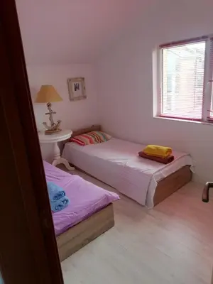 a bedroom with two beds and a table and a window at Sea view apartment in Tsarevo