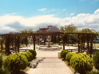 a pergola with a fountain in a park at Sea view apartment in Tsarevo