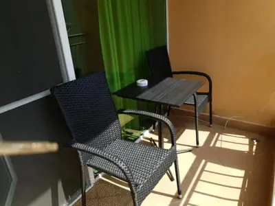 a table and two chairs and a table with a laptop at Апартамент Диана in Pomorie