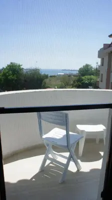 a chair on a balcony with a view of the ocean at Къща за гости Валена град Черноморец in Chernomorets