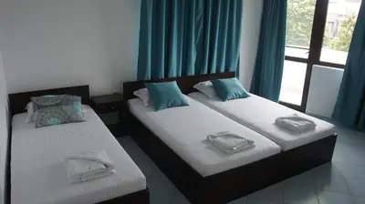 two twin beds in a room with a window at Къща за гости Валена град Черноморец in Chernomorets