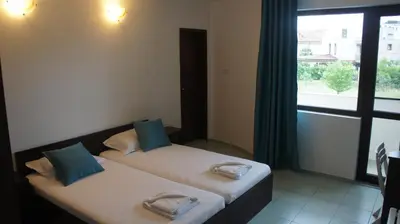 two beds in a room with a window at Къща за гости Валена град Черноморец in Chernomorets