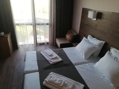 a hotel room with two beds with towels on them at Hotel Vanilla, Varna - Free parking in Varna City