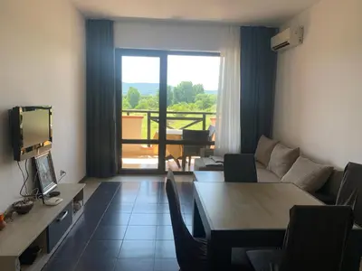 a living room with a couch and a table with chairs at Apartment at St. Nicholas Complex-Igora in Chernomorets