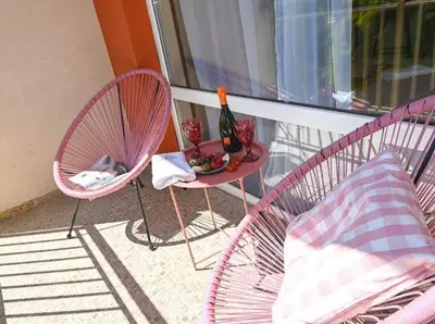 a balcony with two chairs and a table with a bottle of wine at Nessebar Fort Club - Prestige Apartments in Sunny Beach