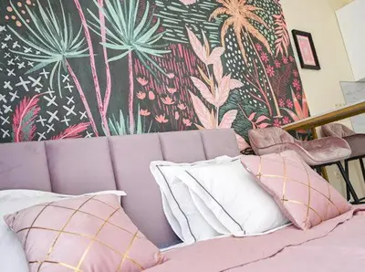 a purple couch with pillows in front of a colorful wall at Nessebar Fort Club - Prestige Apartments in Sunny Beach