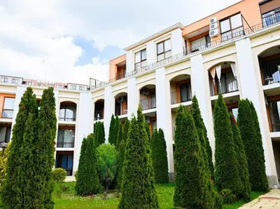 a building with a bunch of trees in front of it at Sea Fort Club & Grand Resort in Sveti Vlas