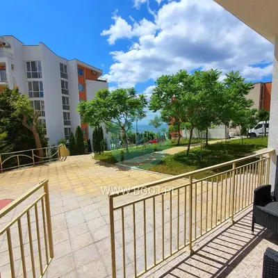 a balcony with a fence and trees and buildings at Grand Resort - Sea Viev and Premium Apartments in Sveti Vlas