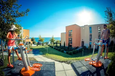 a man and a woman playing on a playground at Grand Resort - Sea Viev and Premium Apartments in Sveti Vlas
