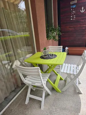 a green table and two chairs on a patio at Бутикови апартаменти Емона in Ravda