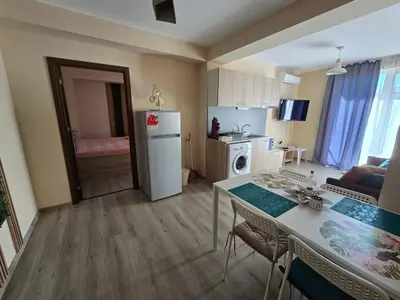 a kitchen and living room with a table and a refrigerator at Бутикови апартаменти Емона in Ravda