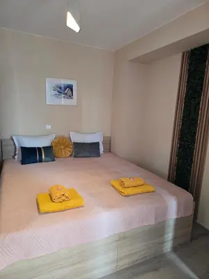 a bedroom with a large bed with yellow towels on it at Бутикови апартаменти Емона in Ravda