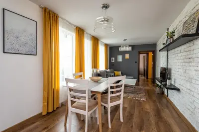 a dining room and living room with a table and chairs at МЯСТОТО in Burgas City